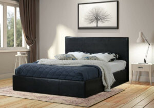 Side view of a double black faux leather ottoman bed in a white bedroom