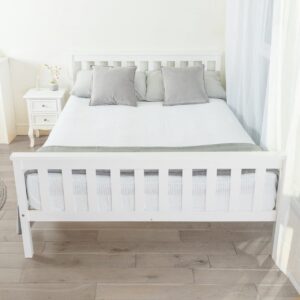 A white double wooden bed made with a white blanket and grey pillows