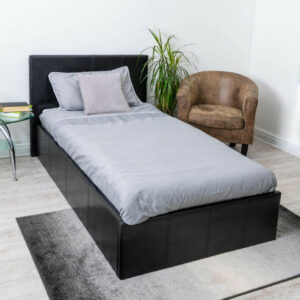 Side view of a black faux leather bed