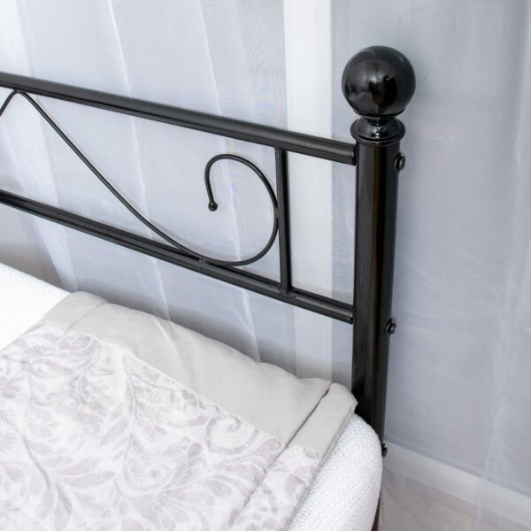 The right knob of a black day bed with a white mattress